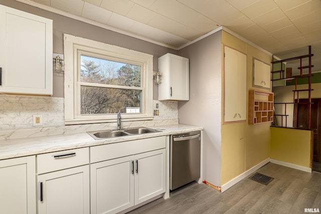 kitchen with sink, white cabinets, backsplash, ornamental molding, and stainless steel dishwasher