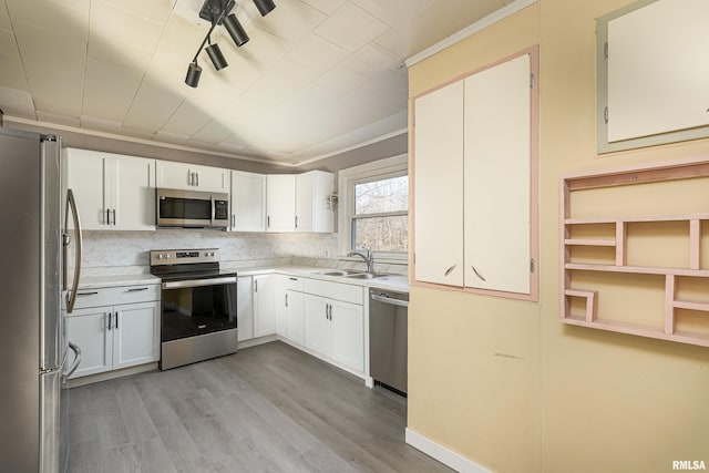 kitchen with sink, decorative backsplash, stainless steel appliances, and white cabinets