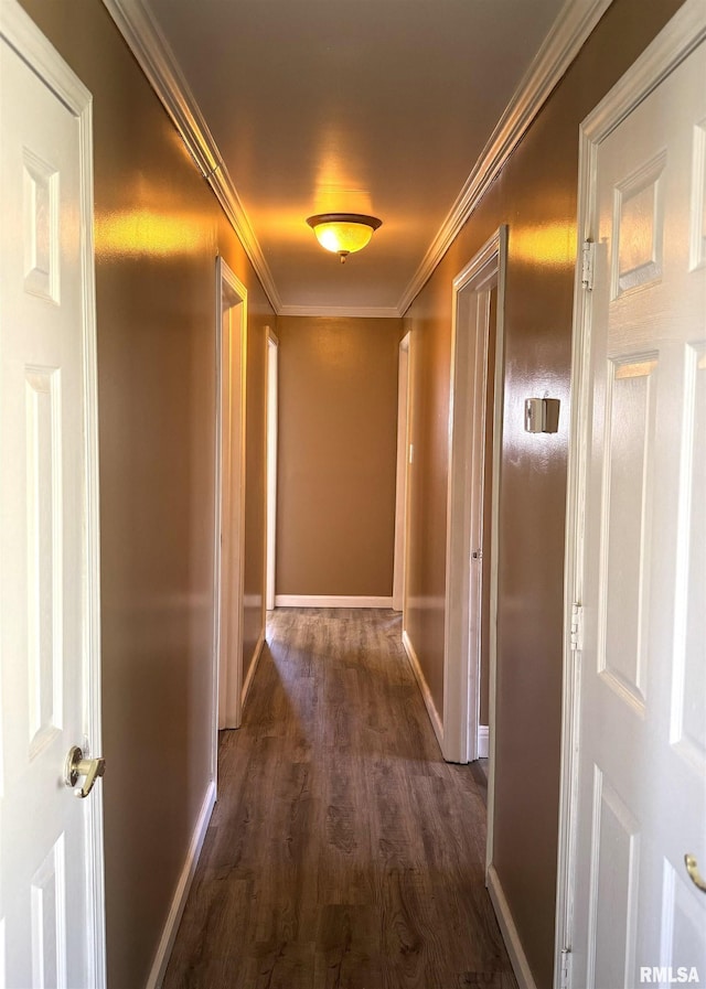 hall with dark wood-style floors, baseboards, and ornamental molding