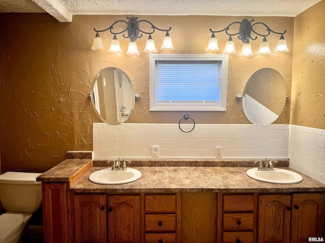 bathroom featuring vanity, a textured ceiling, and toilet