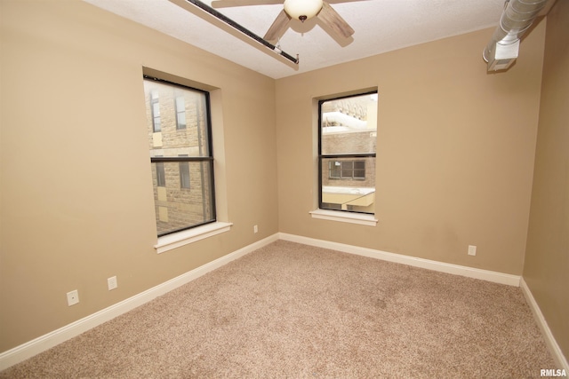 carpeted spare room with ceiling fan