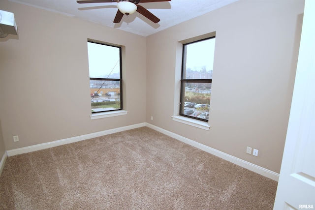 carpeted empty room featuring ceiling fan and a wealth of natural light