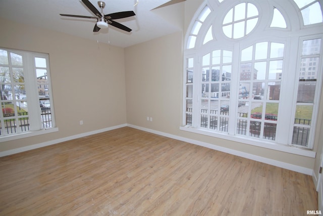 unfurnished room with light hardwood / wood-style floors, ceiling fan, and a healthy amount of sunlight