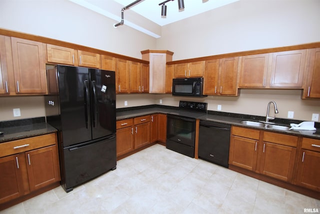 kitchen featuring a high ceiling, sink, dark stone counters, and black appliances