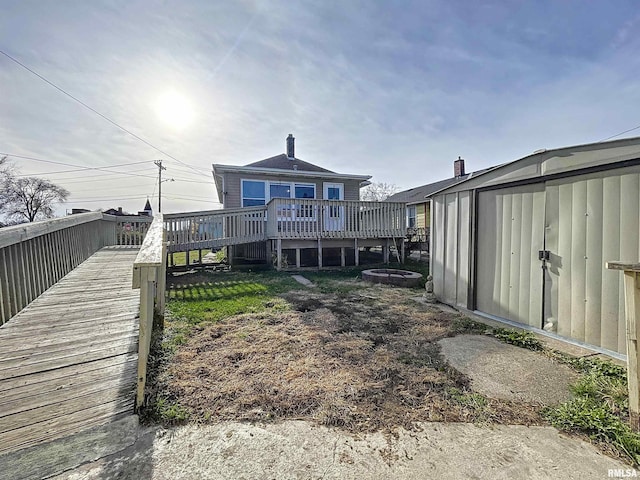 rear view of property with a shed and a wooden deck