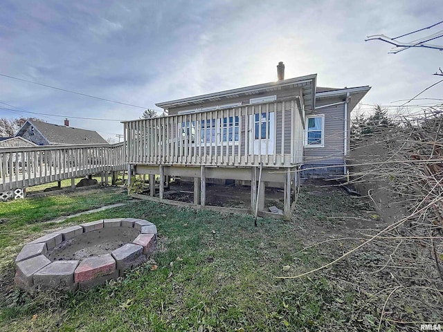 rear view of house featuring a deck and an outdoor fire pit