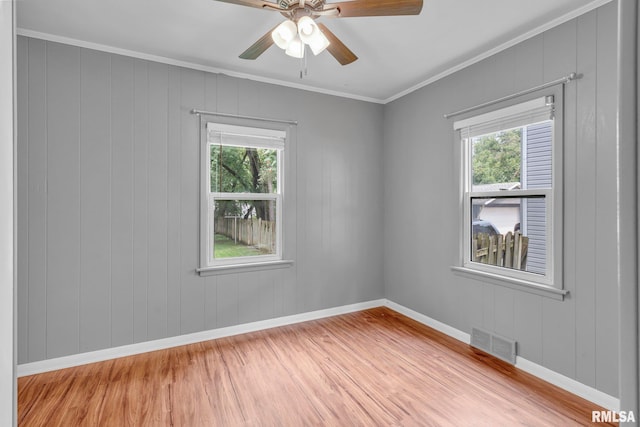 unfurnished room featuring plenty of natural light, ornamental molding, and light hardwood / wood-style flooring