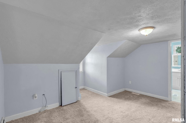 bonus room with light colored carpet, lofted ceiling, and a textured ceiling