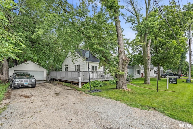 view of front of house featuring an outbuilding, a garage, a front lawn, and a wooden deck