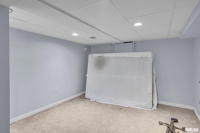 carpeted empty room featuring a drop ceiling