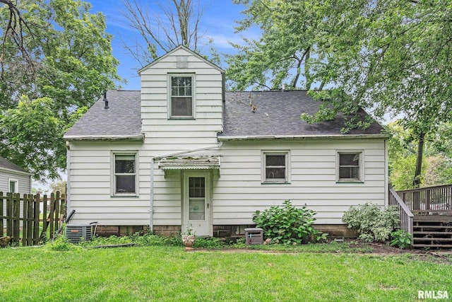 rear view of property with a lawn, cooling unit, and a wooden deck