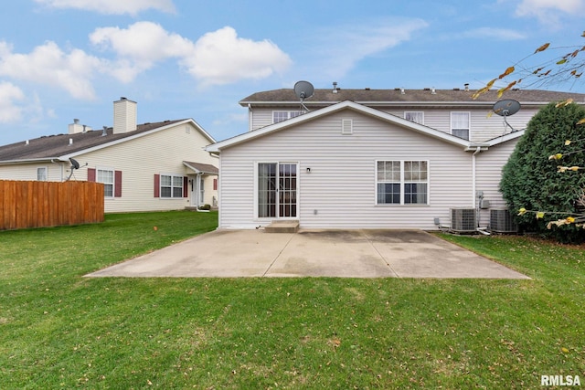 back of property with a lawn, a patio, and central AC