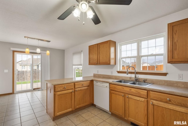 kitchen featuring kitchen peninsula, sink, light tile patterned floors, decorative light fixtures, and dishwasher