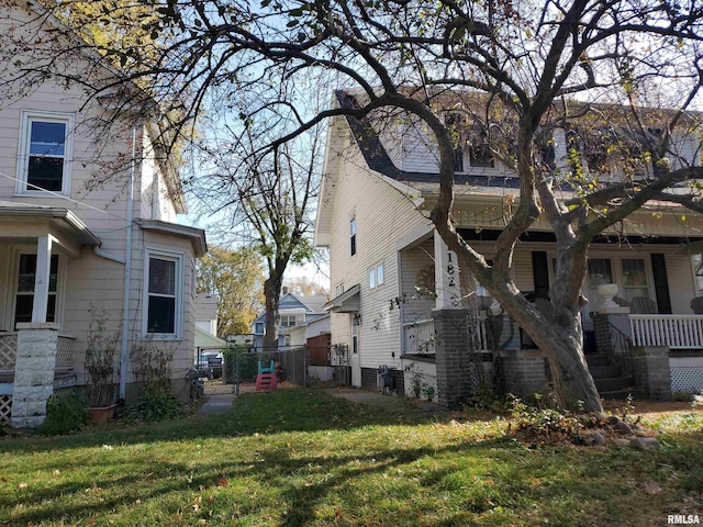 view of home's exterior with covered porch and a yard