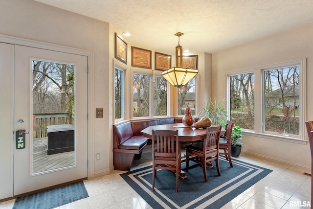 tiled dining space with plenty of natural light and a textured ceiling