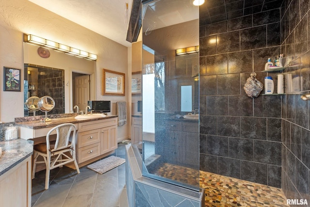 bathroom with vanity and a tile shower