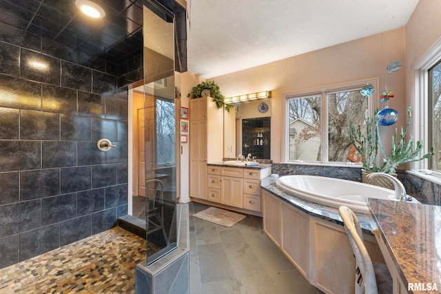 bathroom featuring shower with separate bathtub and vanity