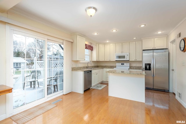 kitchen with sink, white cabinets, stainless steel appliances, and light wood-type flooring