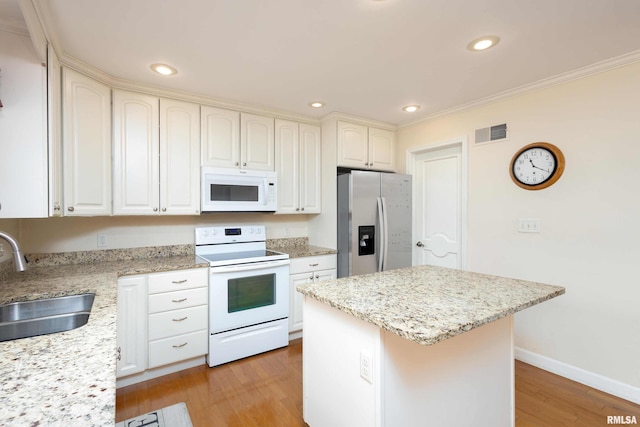 kitchen with sink, a center island, light hardwood / wood-style floors, and white appliances