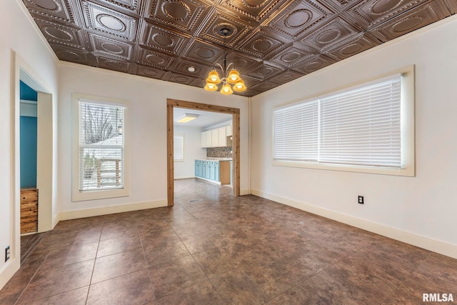 unfurnished room with a notable chandelier and dark tile patterned floors