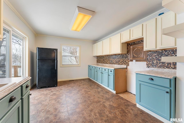 kitchen with decorative backsplash, black fridge, crown molding, and tile patterned flooring