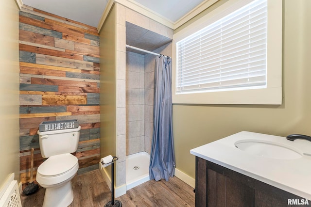 bathroom featuring curtained shower, hardwood / wood-style floors, toilet, wooden walls, and vanity