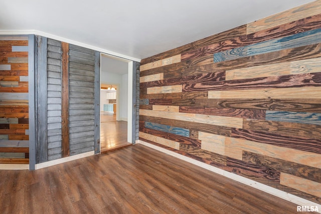 empty room featuring wooden walls and dark wood-type flooring