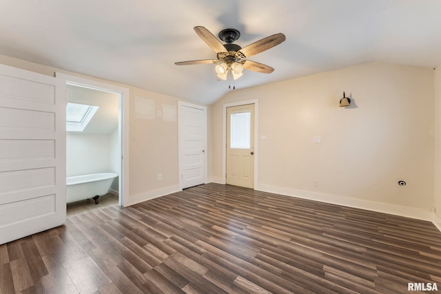 additional living space featuring dark hardwood / wood-style flooring, lofted ceiling with skylight, and ceiling fan