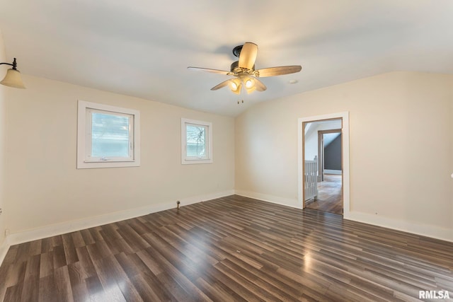 empty room with ceiling fan, dark hardwood / wood-style flooring, and vaulted ceiling