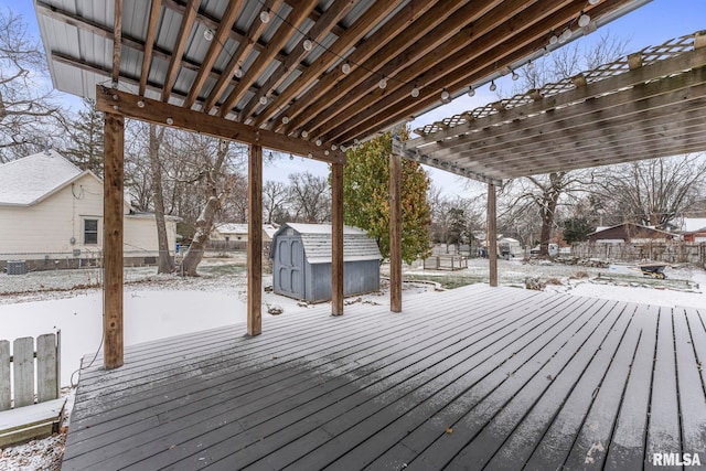 snow covered deck featuring a storage shed