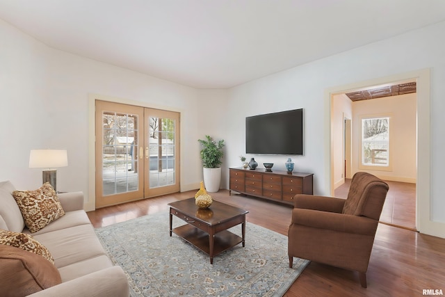 living room with french doors, a healthy amount of sunlight, and hardwood / wood-style floors