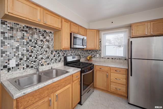 kitchen with backsplash, light stone countertops, sink, and appliances with stainless steel finishes