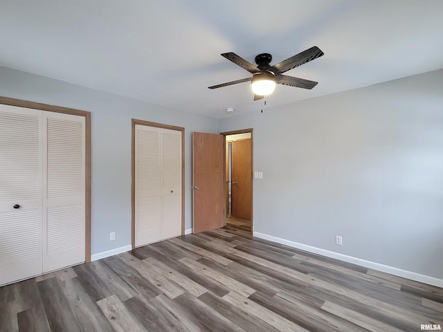 unfurnished bedroom with ceiling fan, multiple closets, and light hardwood / wood-style flooring