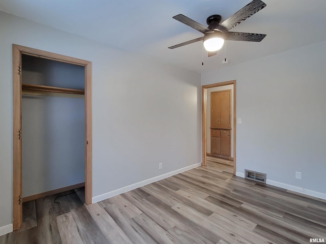 unfurnished bedroom featuring a closet, light hardwood / wood-style flooring, and ceiling fan