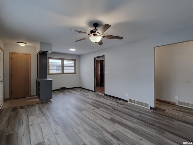 unfurnished living room featuring ceiling fan and light hardwood / wood-style flooring