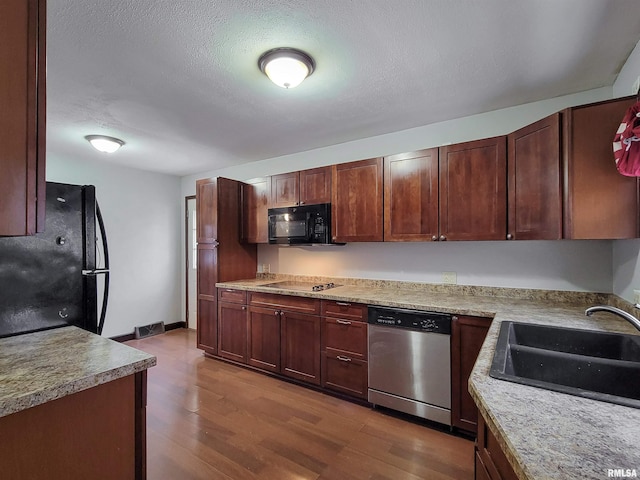 kitchen with black appliances, light hardwood / wood-style floors, sink, and a textured ceiling