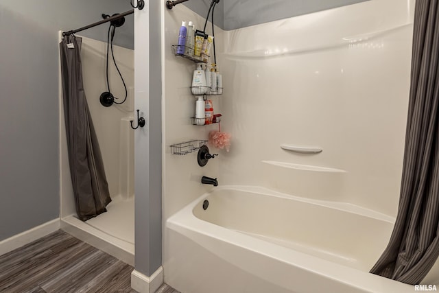 bathroom with hardwood / wood-style flooring and shower / tub combo with curtain