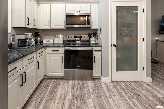 kitchen with white cabinets, appliances with stainless steel finishes, and light wood-type flooring