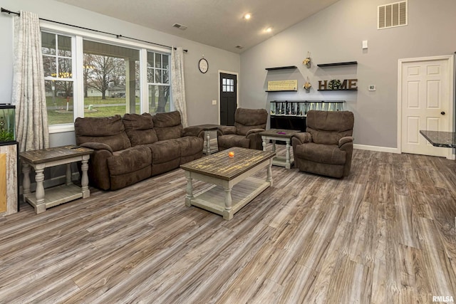 living room with high vaulted ceiling and hardwood / wood-style flooring