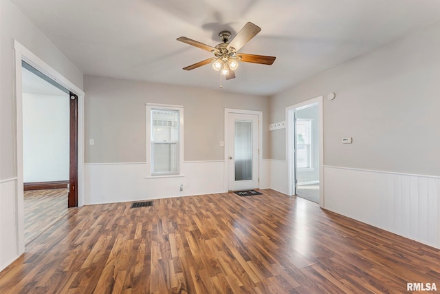 spare room with plenty of natural light, dark hardwood / wood-style floors, and ceiling fan