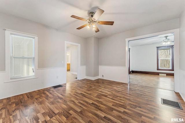 unfurnished room with dark hardwood / wood-style flooring and ceiling fan