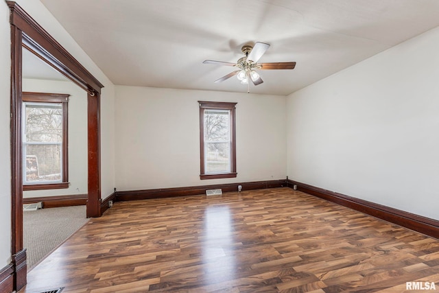 spare room featuring dark hardwood / wood-style flooring, plenty of natural light, and ceiling fan