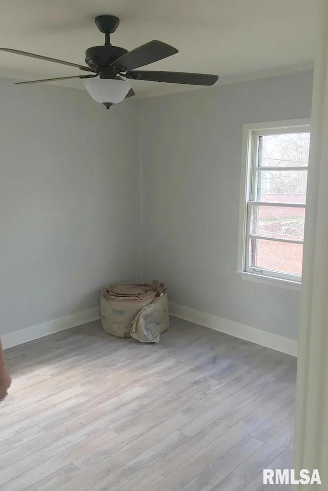 unfurnished room with a ceiling fan, light wood-style flooring, and baseboards