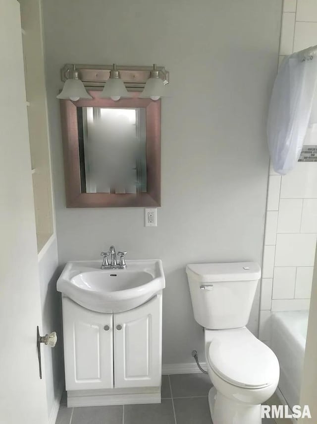 bathroom with baseboards, vanity, toilet, and tile patterned floors