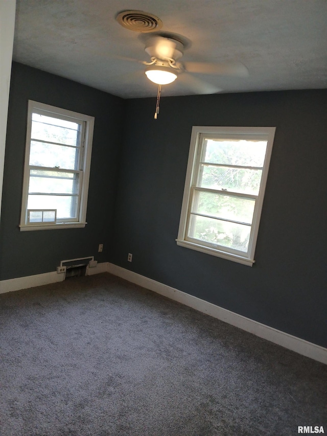 spare room featuring carpet flooring, ceiling fan, visible vents, and baseboards