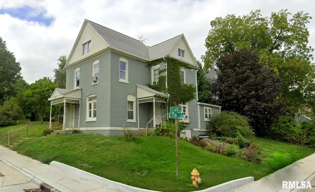 view of front facade featuring cooling unit and a front yard