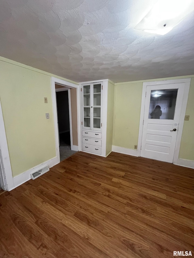 interior space with a textured ceiling and hardwood / wood-style flooring