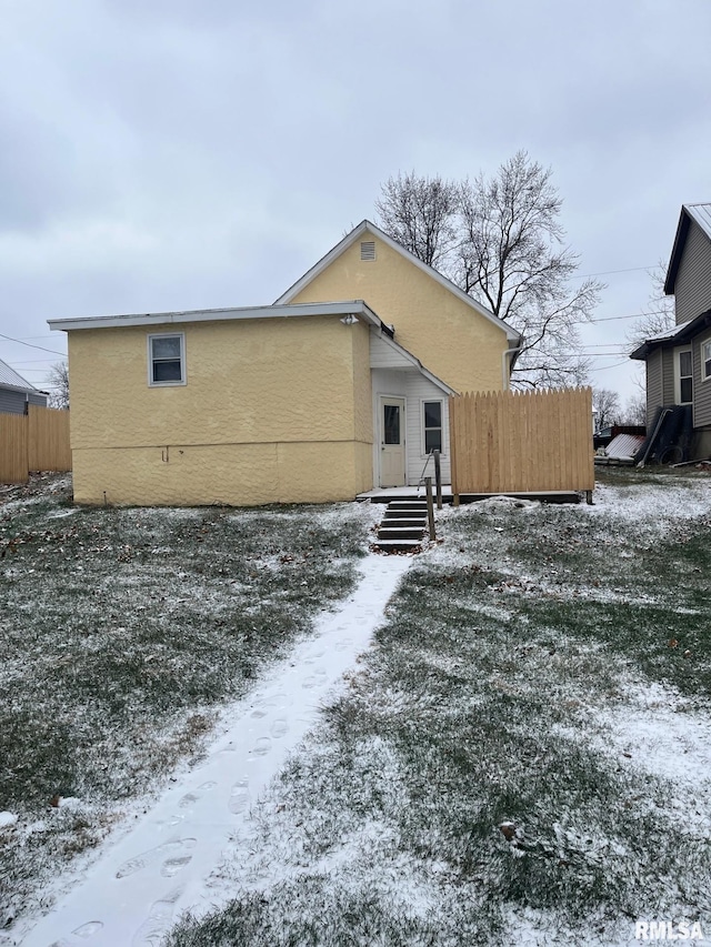 view of snow covered rear of property