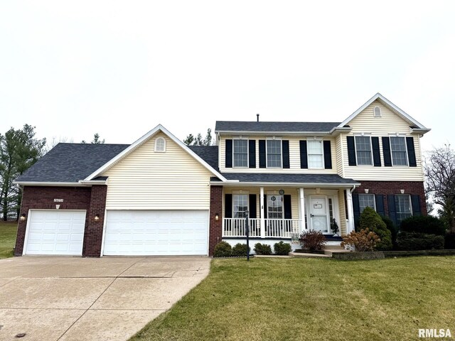 view of front facade featuring a porch, a garage, and a front lawn