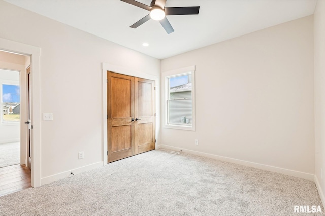 unfurnished bedroom with ceiling fan and light colored carpet